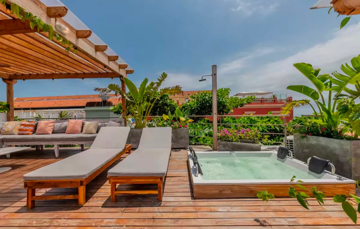 Una terraza privada en la azotea con camastros y piscina, con vista al centro histórico de Cartagena
