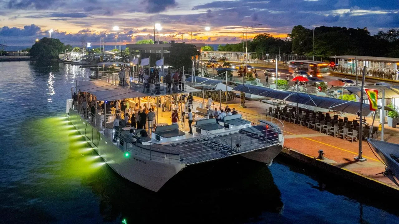 Un catamarán privado iluminado en el muelle de Cartagena al anochecer